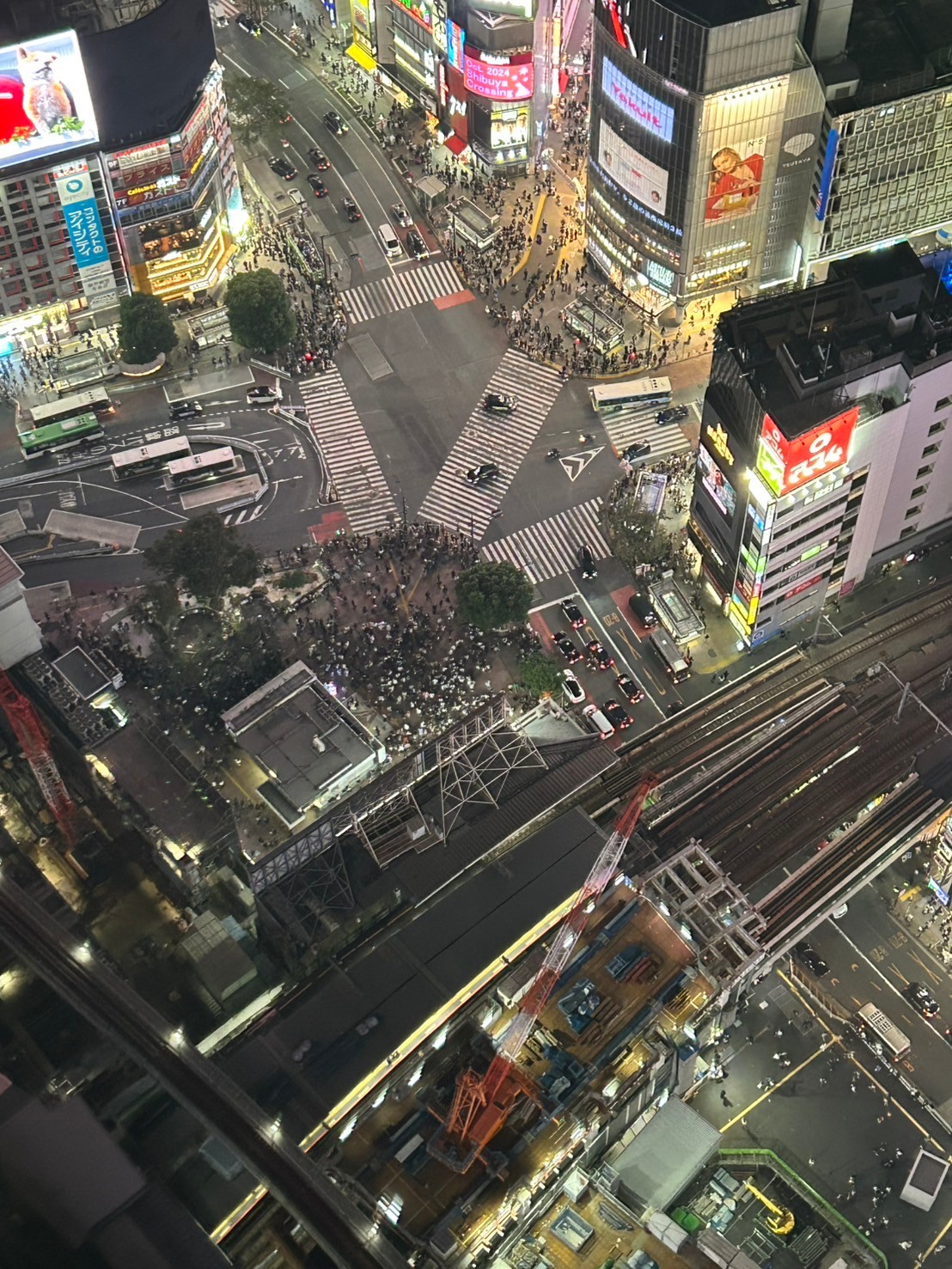 Tokyo from Shibuya Sky at dusk—the neon core of Shibuya against the residential spread of the western wards