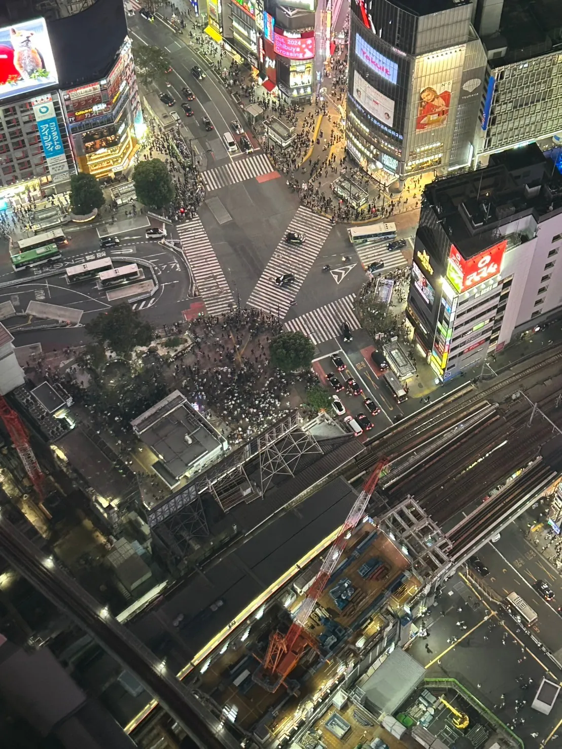 Tokyo from Shibuya Sky at dusk—the neon core of Shibuya against the residential spread of the western wards
